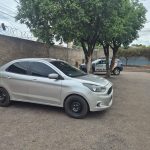 Viatura da Polícia Militar parada ao lado de um Ford Ka cinza recuperado em rua do Parque Rosa Bororo, em Rondonópolis, após alerta do sistema Vigia sobre furto do veículo