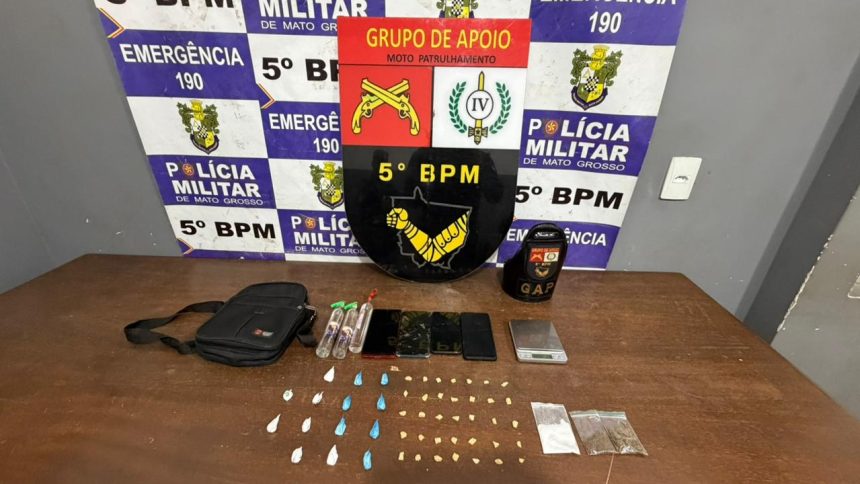 Policiais militares ao lado de viatura em rua da região central de Rondonópolis, com bolsa preta e drogas apreendidas em ação contra o tráfico de entorpecentes