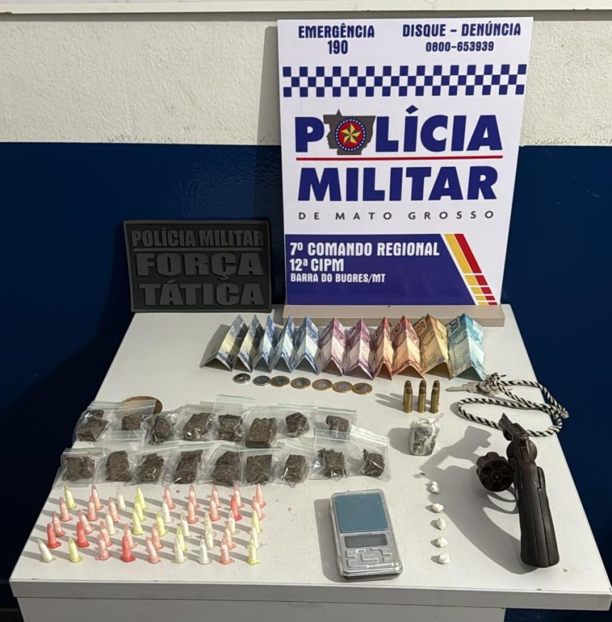 Foto de armas de fogo e porções de drogas apreendidas pela Polícia Militar sobre uma mesa.