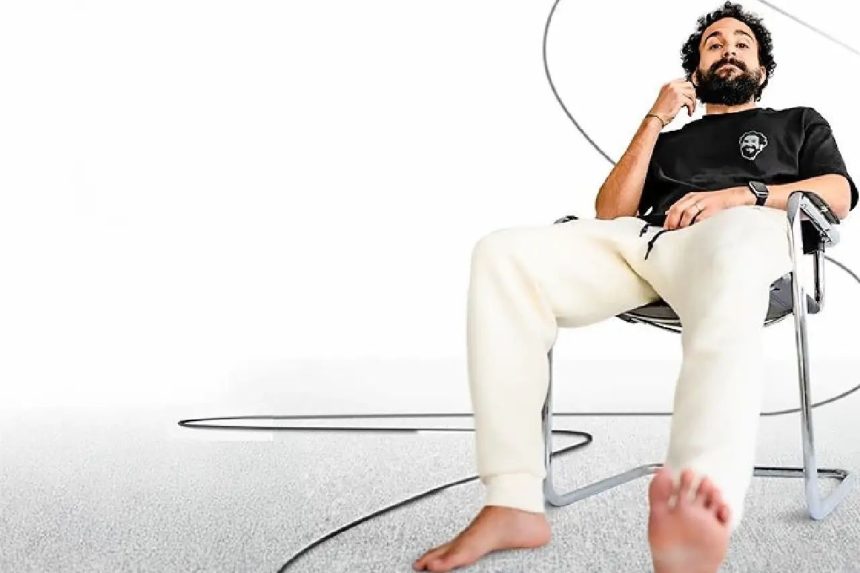 Comediante Murilo Couto em apresentação de stand-up, de frente para o público, segurando microfone durante show sobre casamento.