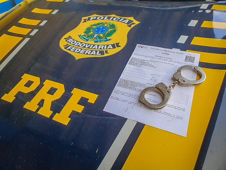 Viatura da Polícia Rodoviária Federal estacionada em rodovia durante abordagem a ônibus.