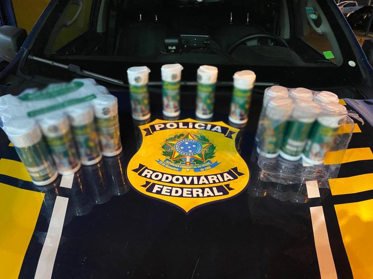 Frascos de metanfetamina apreendidos pela PRF em Rondonópolis dentro de uma caixa de papelão.