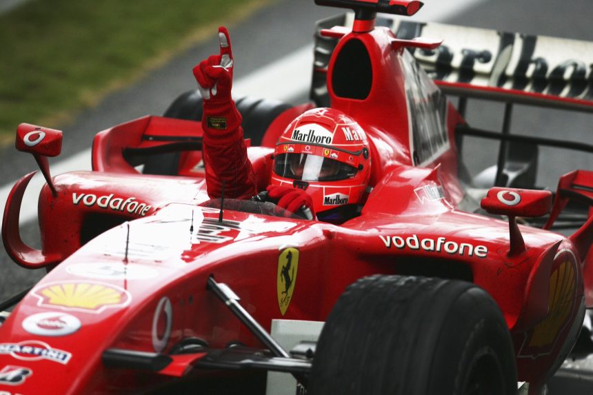 Fotografia de Michael Schumacher com o uniforme vermelho da escuderia Ferrari.