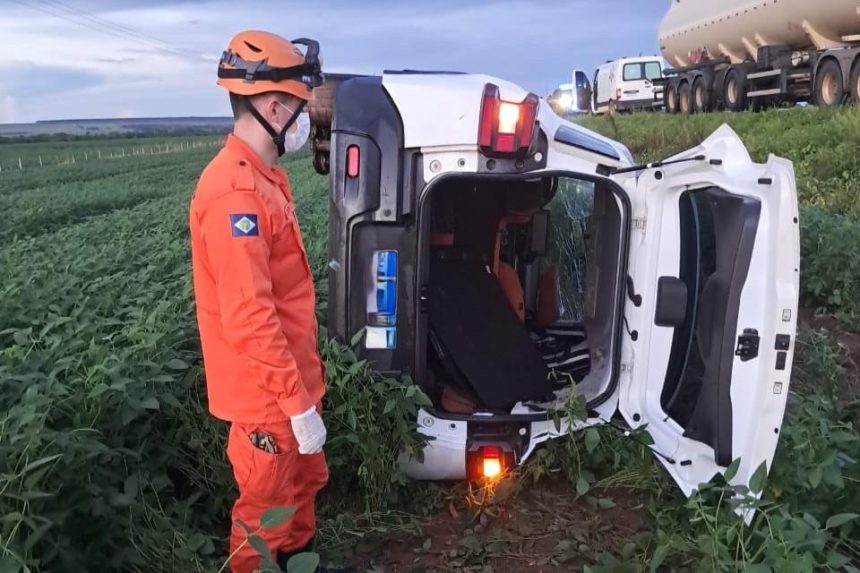 Equipe dos Bombeiros Militares realizando atendimento em veículo capotado em plantação de soja.