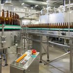 Vista interna de uma unidade de processamento industrial com máquinas modernas.