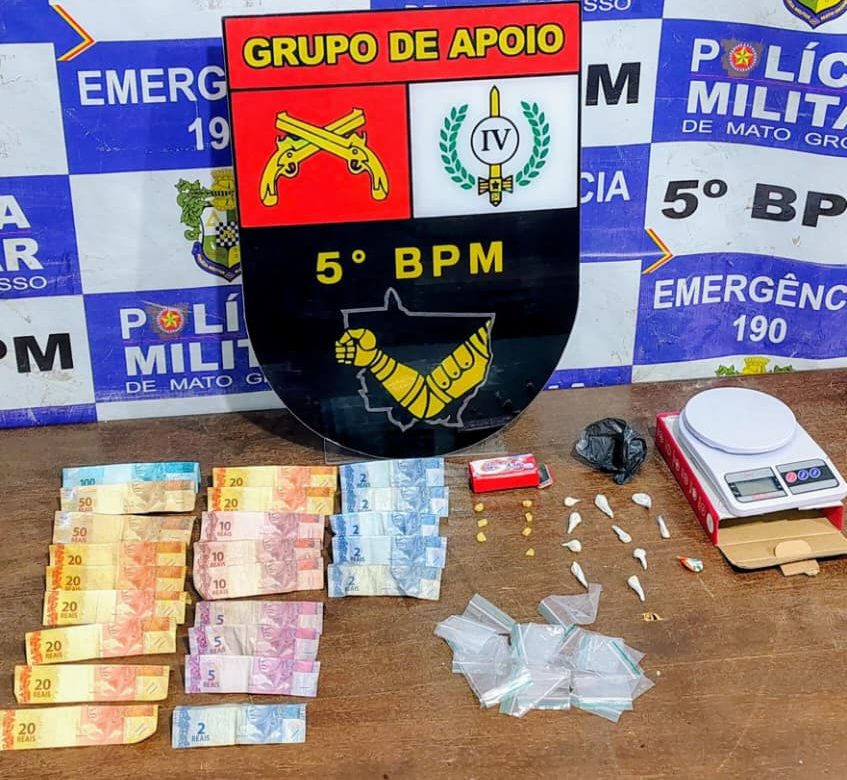 Foto exibe porções de cocaína, balança de precisão e dinheiro apreendidos pela Polícia Militar de Rondonópolis.