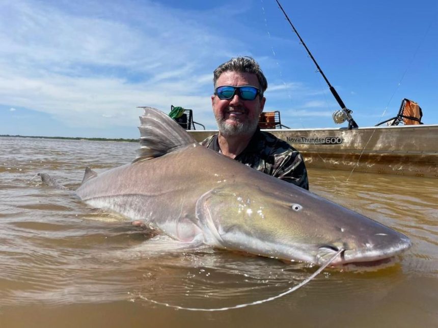 Pescador praticando a modalidade pesque e solte em um rio de Mato Grosso durante o pôr do sol.