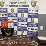 Porções de maconha e cocaína apreendidas pela Polícia Militar sobre uma mesa.