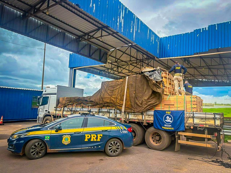 Agentes da PRF fiscalizam carga de madeira nativa em caminhão parado no acostamento da rodovia em Rondonópolis.